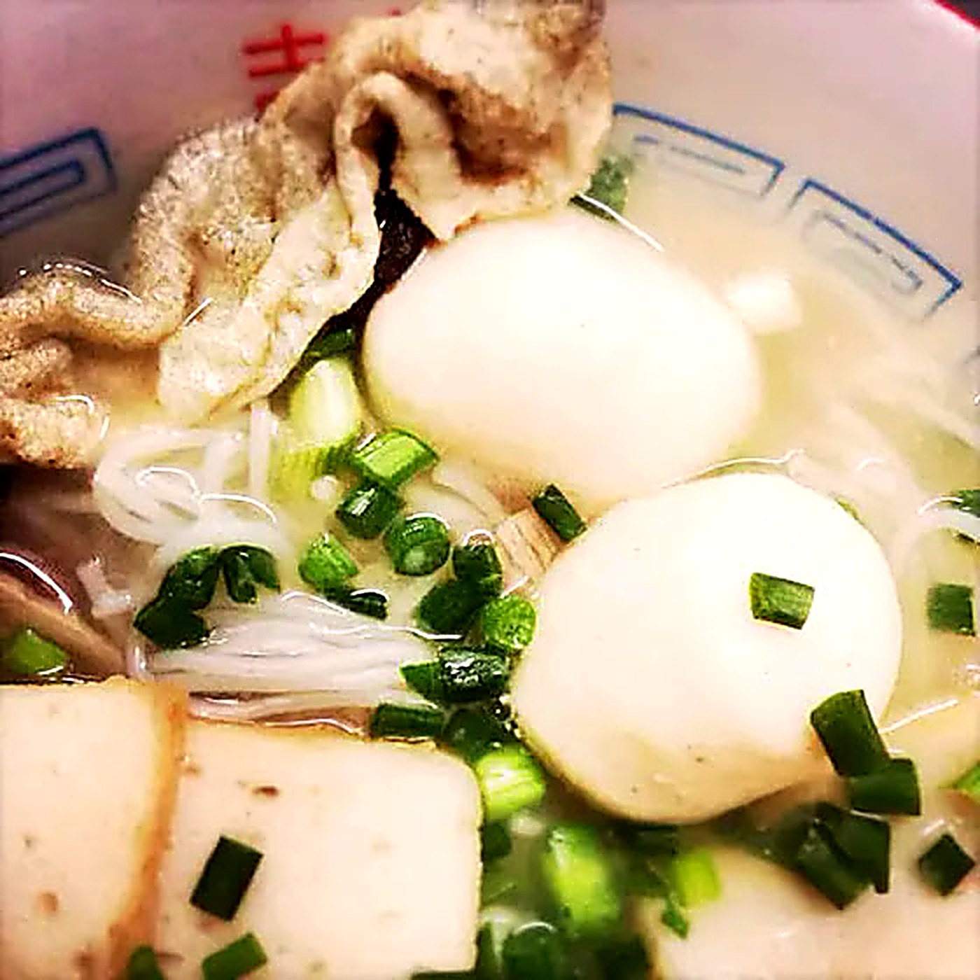 Fish skin served over noodle soup with fish balls and spring onion
